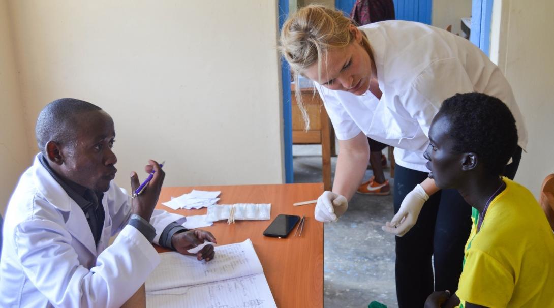 A recent graduate participates in a community outreach with a local doctor as part of her internship abroad. A recent graduate interning abroad assists a local doctor during a medical outreach in Kenya.